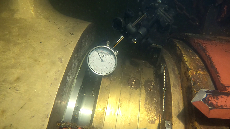 underwater image of a dial indicator attached to the ship liner of a large vessel